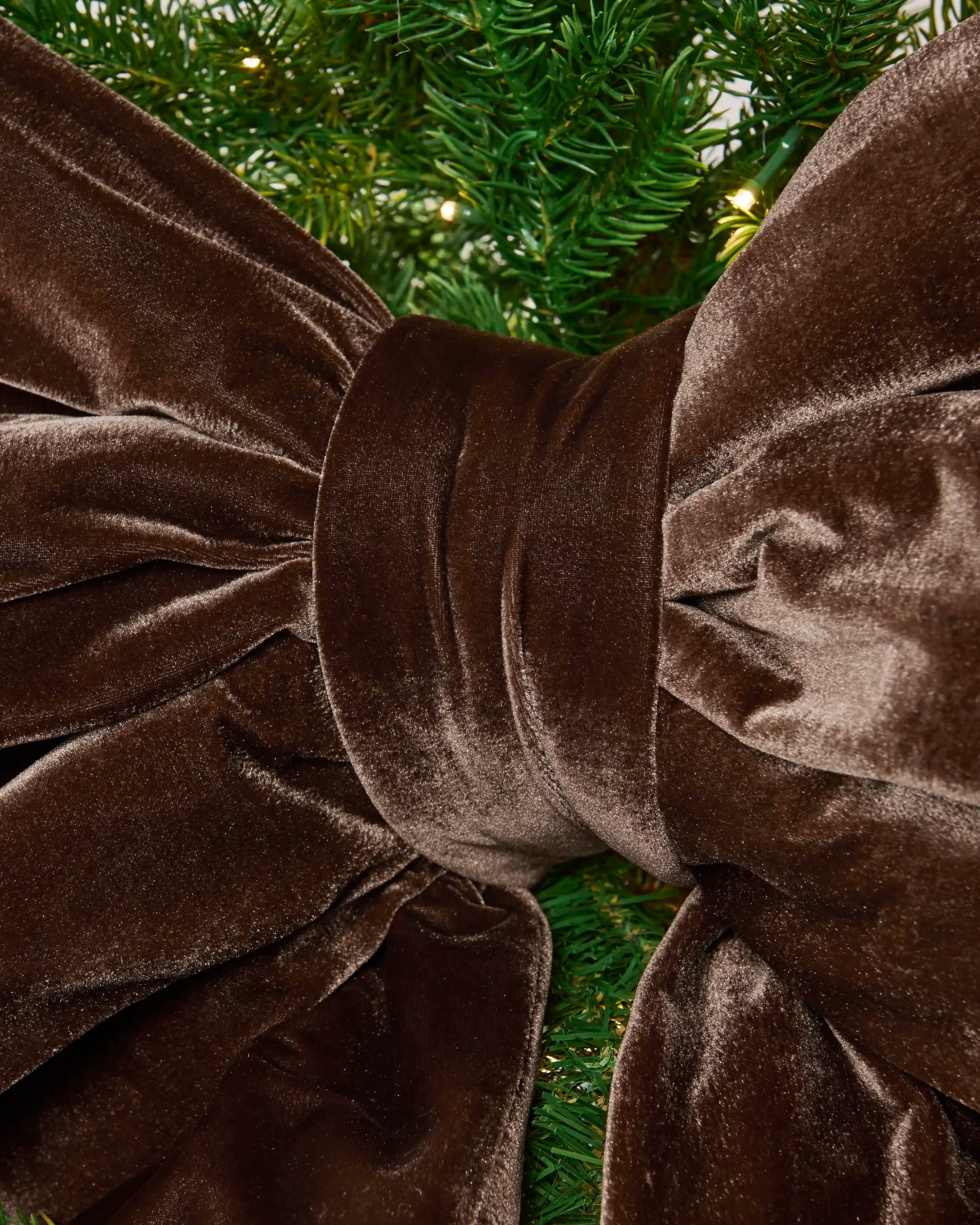 Detailed close-up of the espresso velvet Christmas bow showing the padded centre knot and gathered fabric.