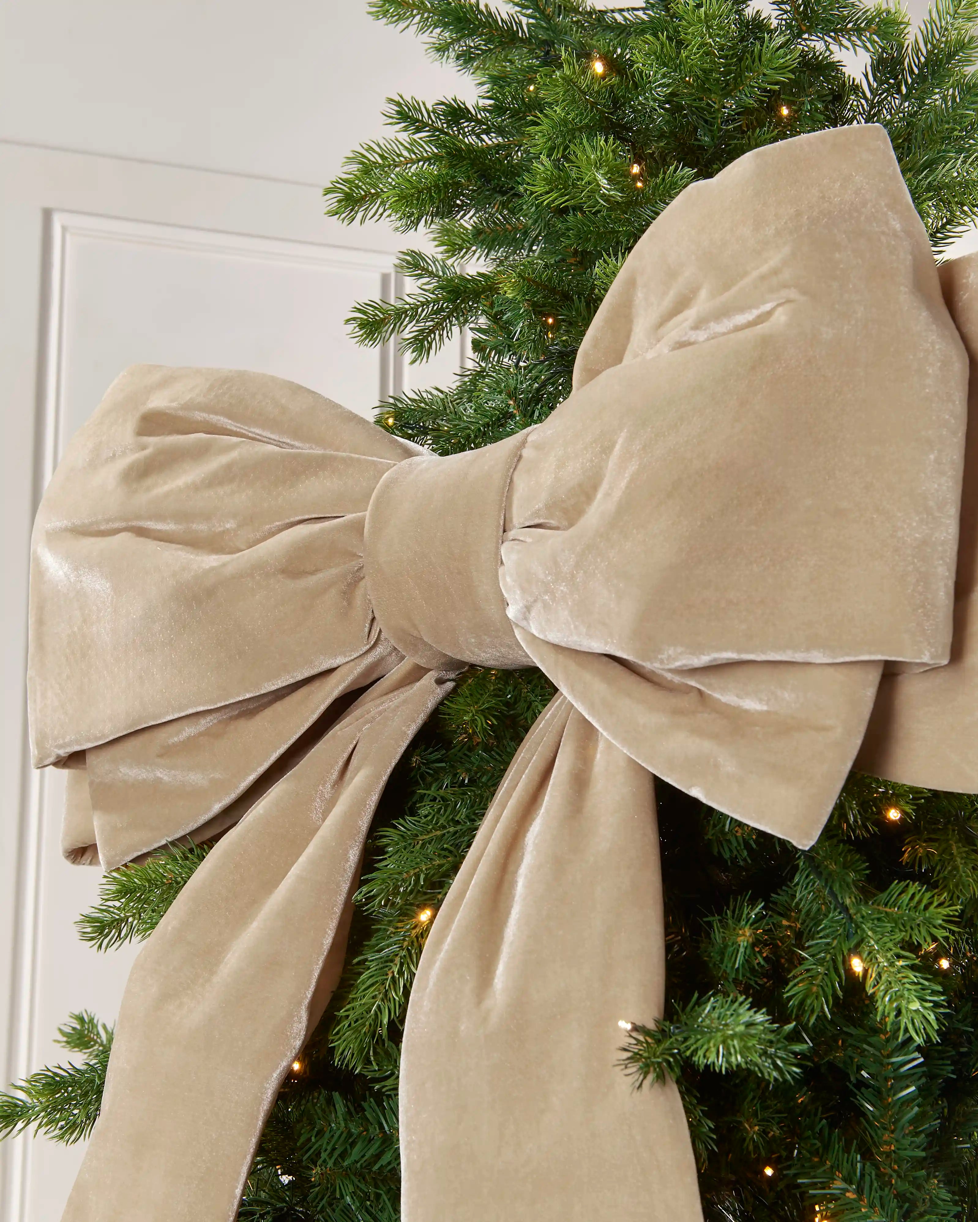 Close-up of the large latte velvet Christmas bow showing its layered structured loops and soft finish.