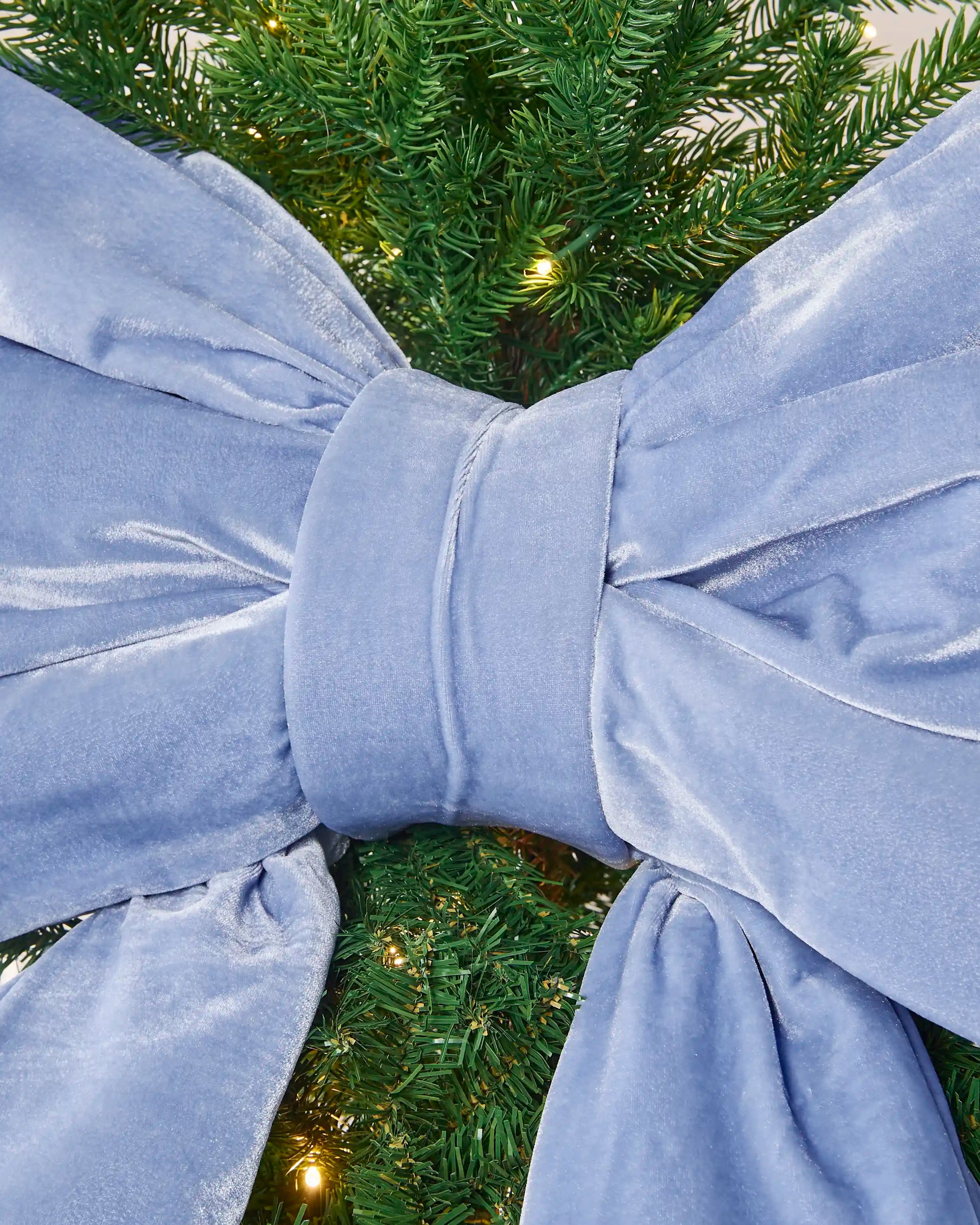 Close-up of the ice blue velvet Christmas bow showing the padded centre knot and gathered fabric.