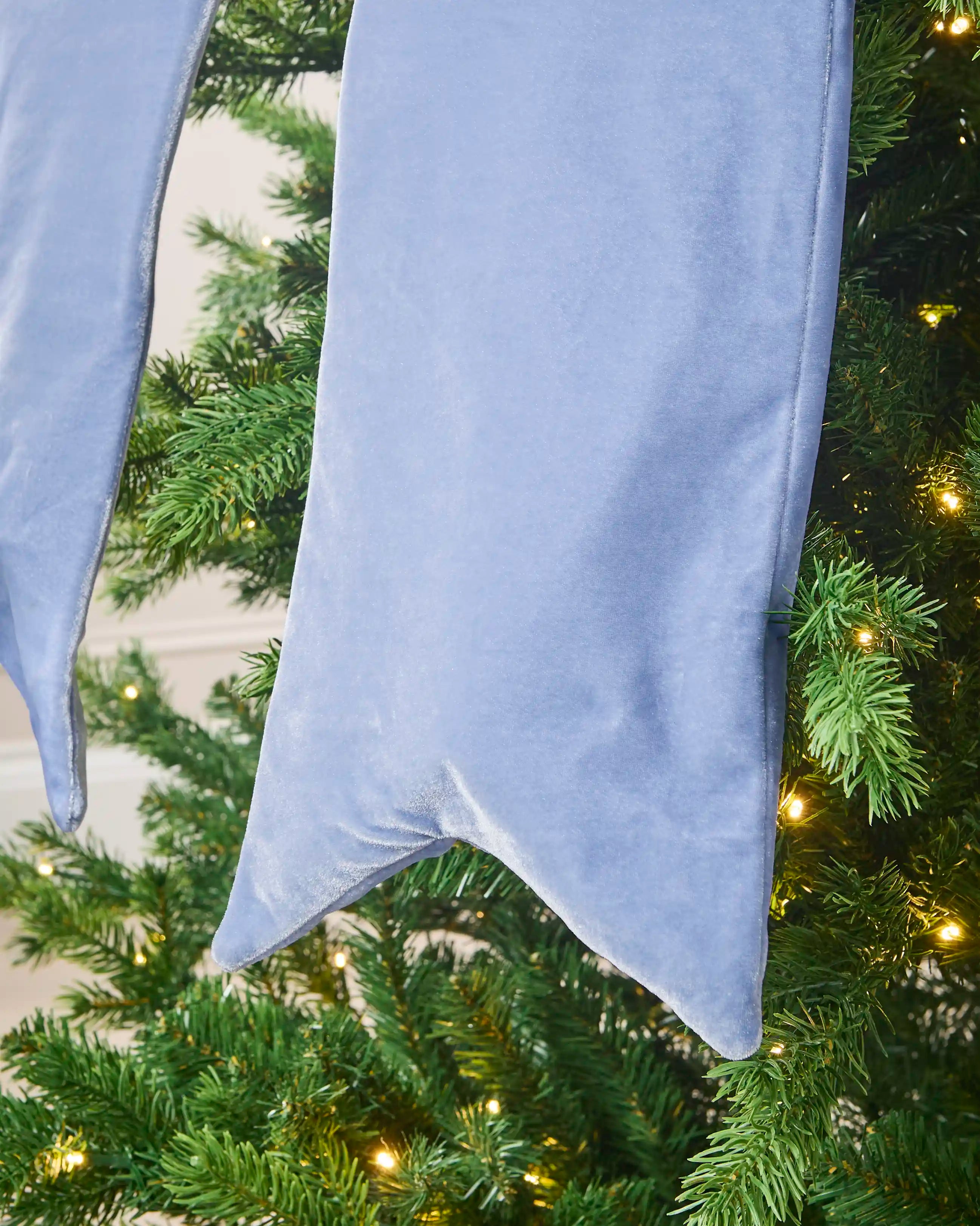 Close-up of the long ice blue velvet Christmas bow tail with a pointed finish.