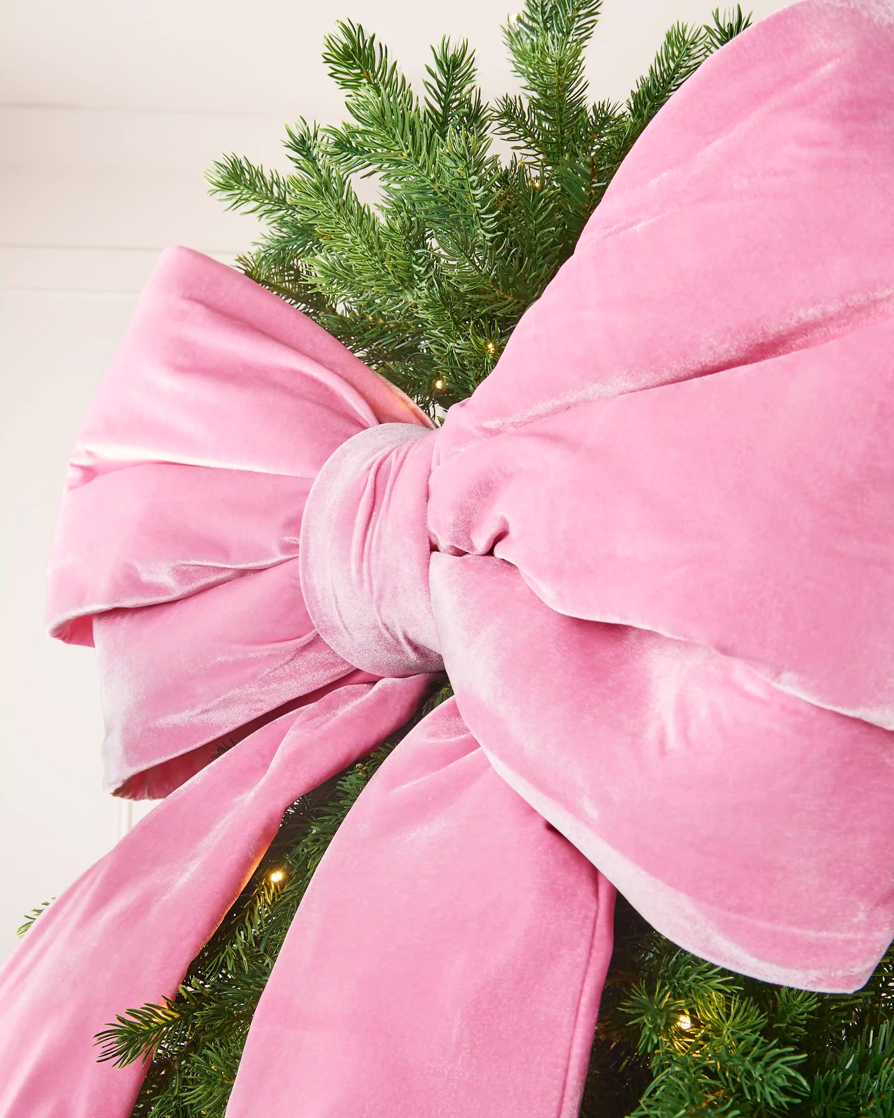 Close-up of the large pink velvet Christmas bow showing its full layered loops.
