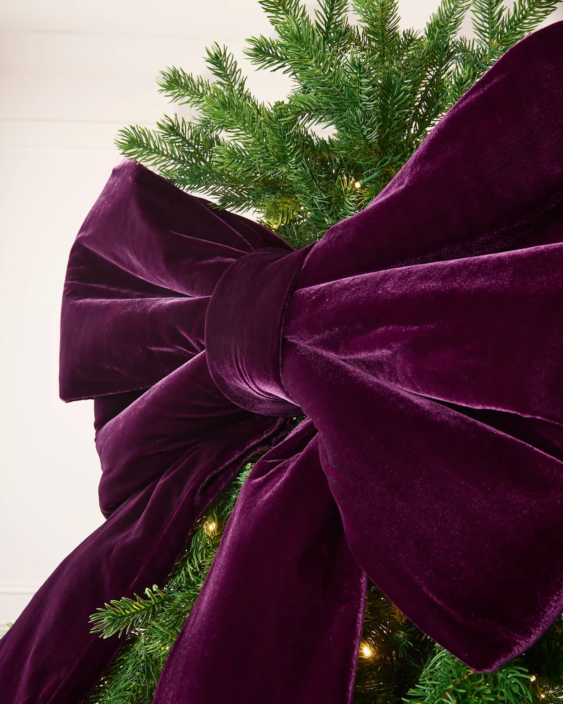 Close-up of the large purple velvet Christmas bow showing its full layered loops.