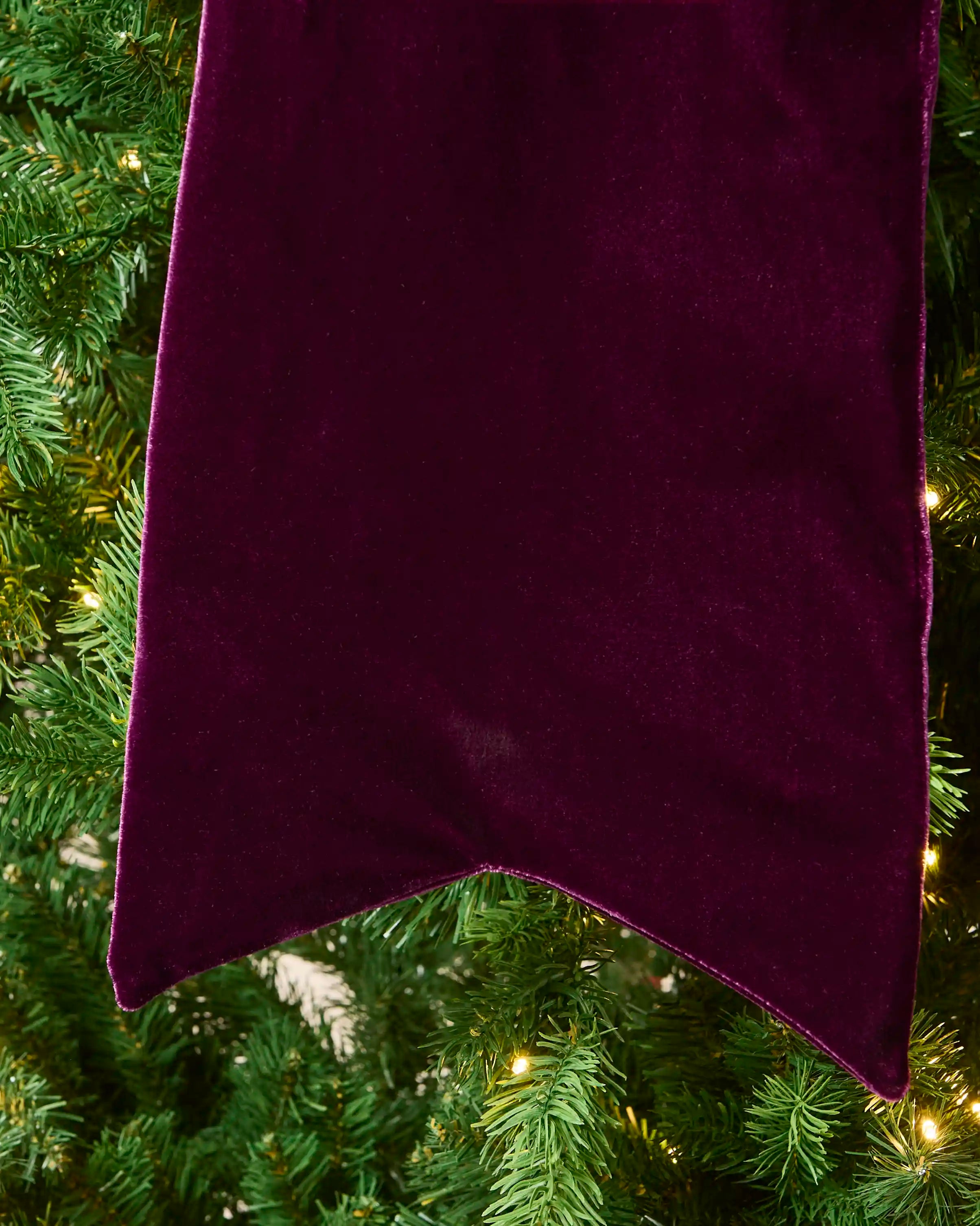Close-up of the long purple velvet Christmas bow tail with a pointed finish.