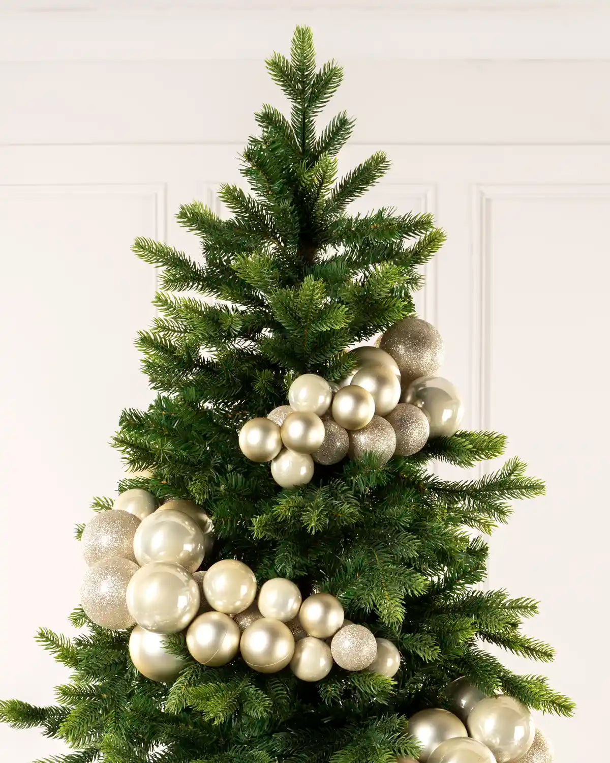 Close-up of latte baubles showing shiny, matt and glitter finishes on a Christmas tree.