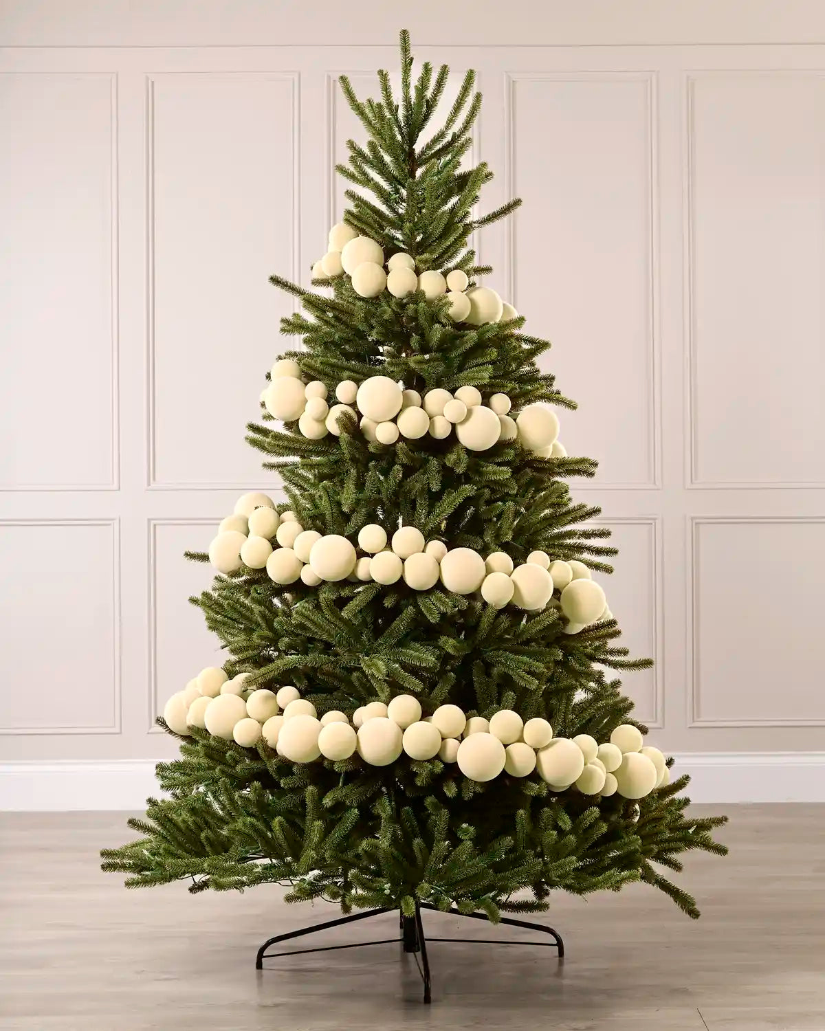 Latte velvet bauble garland wrapped around a green Christmas tree with mixed 5cm, 7cm and 10cm baubles.