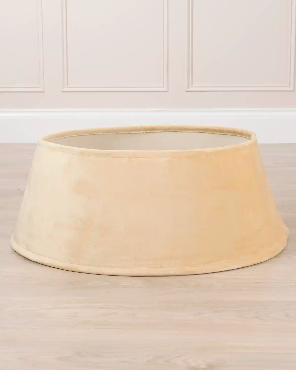 latte coloured Christmas tree skirt on cream floor against a beige background