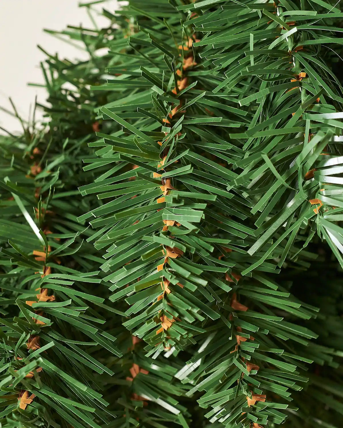 Macro detail of green PVC foliage tips on the majestic Christmas wreath