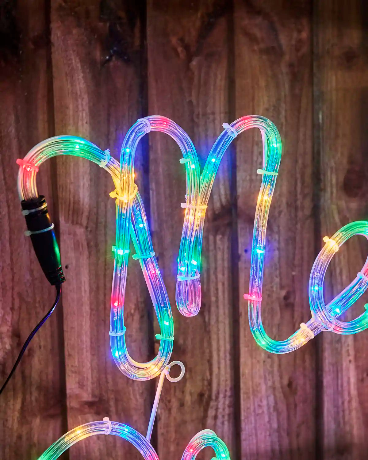 Close-up of the illuminated Merry script on the 100 cm multi-coloured LED Merry Christmas rope light display.