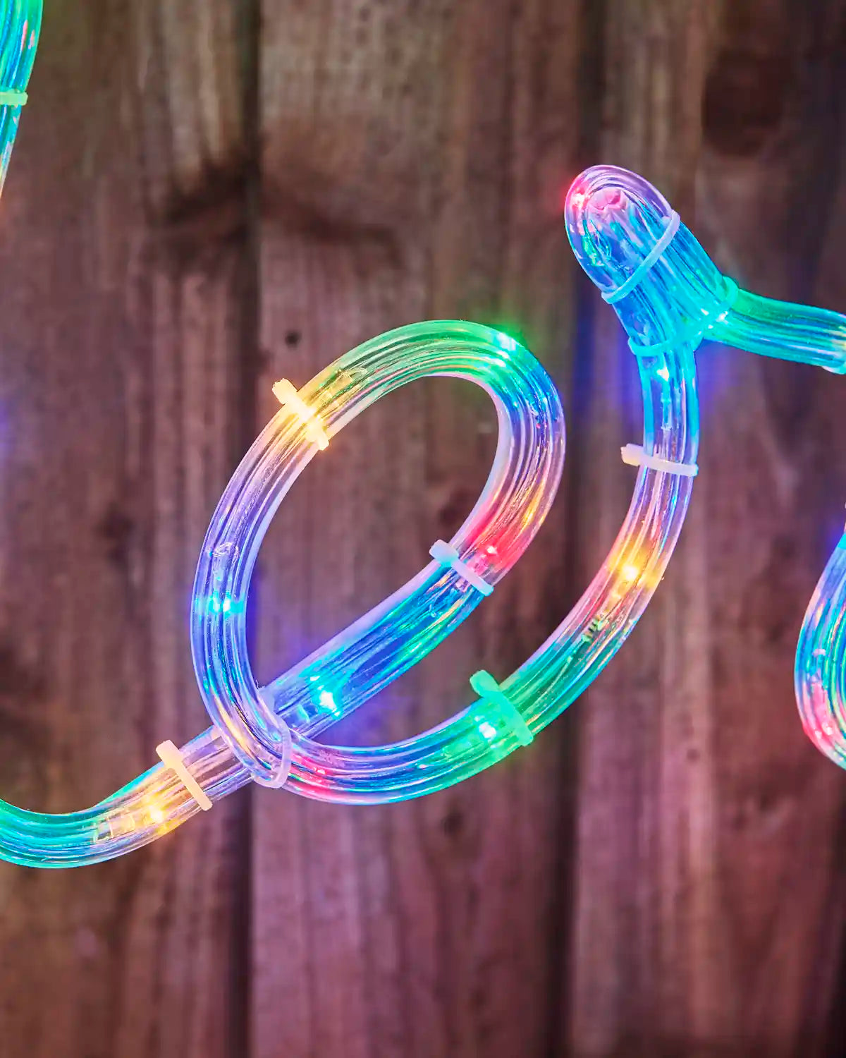 Detailed close-up of the clear rope tubing and multi-coloured LEDs on the 100 cm Merry Christmas light display.