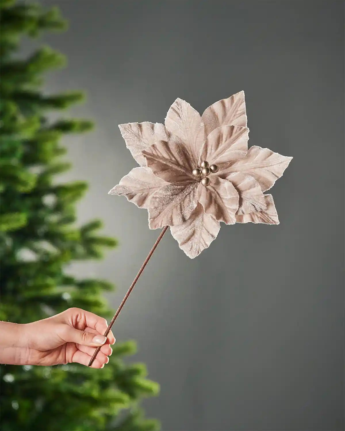 26 cm mocha artificial poinsettia flower held by its brown stem, showing the full layered flower head.