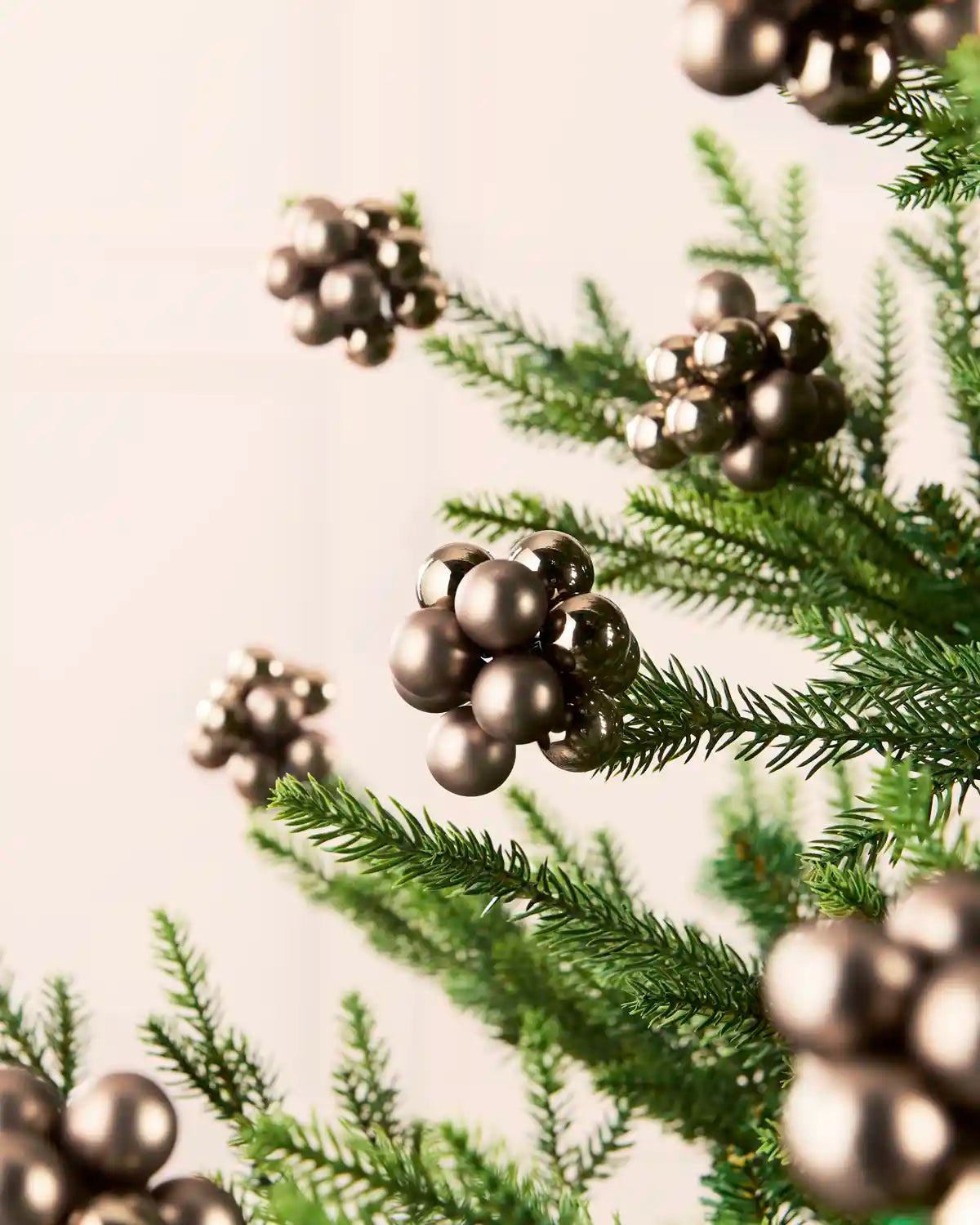Mocha glass berry cluster baubles arranged throughout a green Christmas tree.