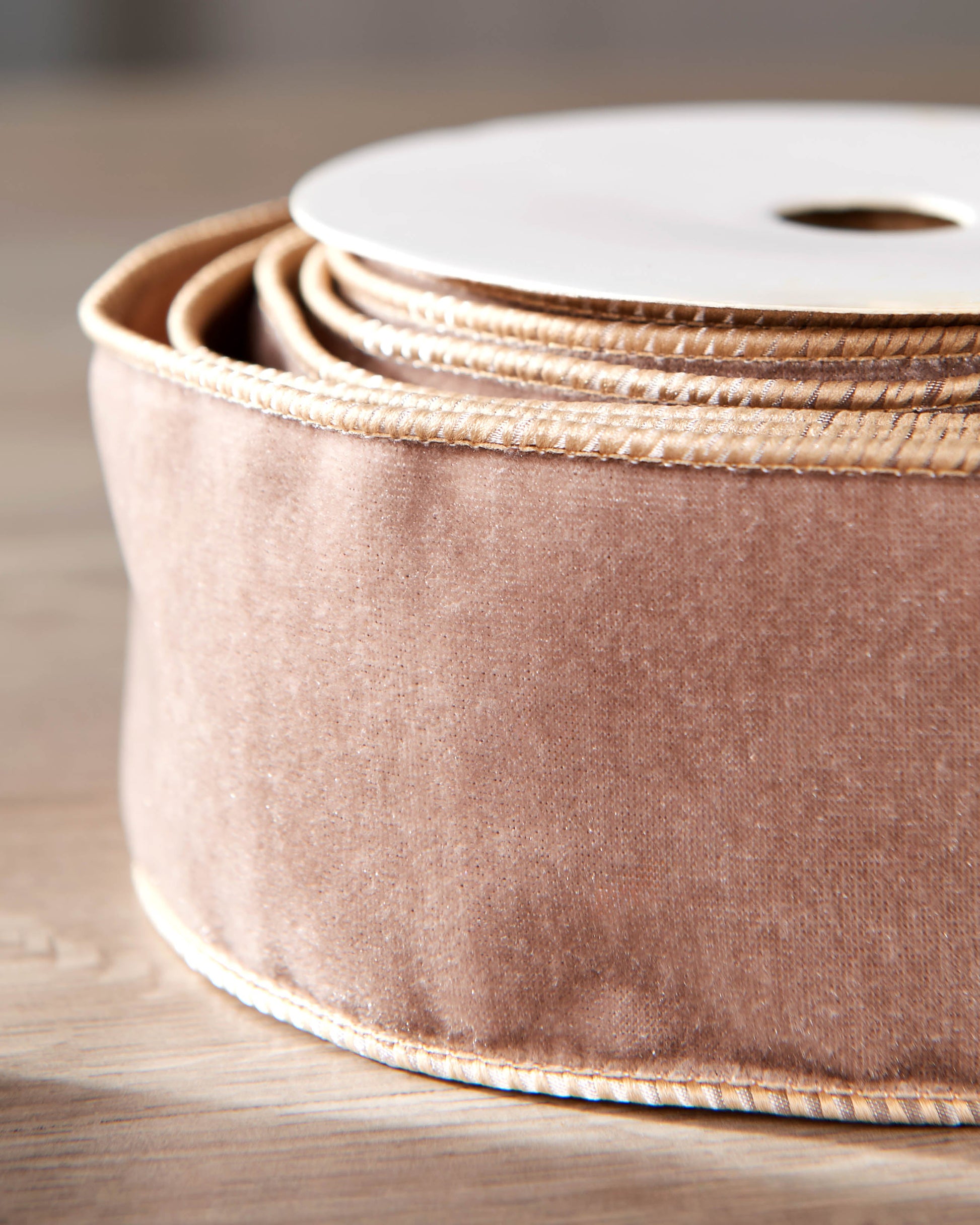 Close-up of mocha velvet ribbon on a roll, showing the soft texture and wired edge.