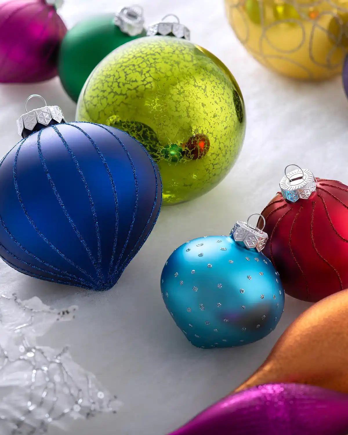 Multi-colour glass baubles displayed in styled flat lay arrangement