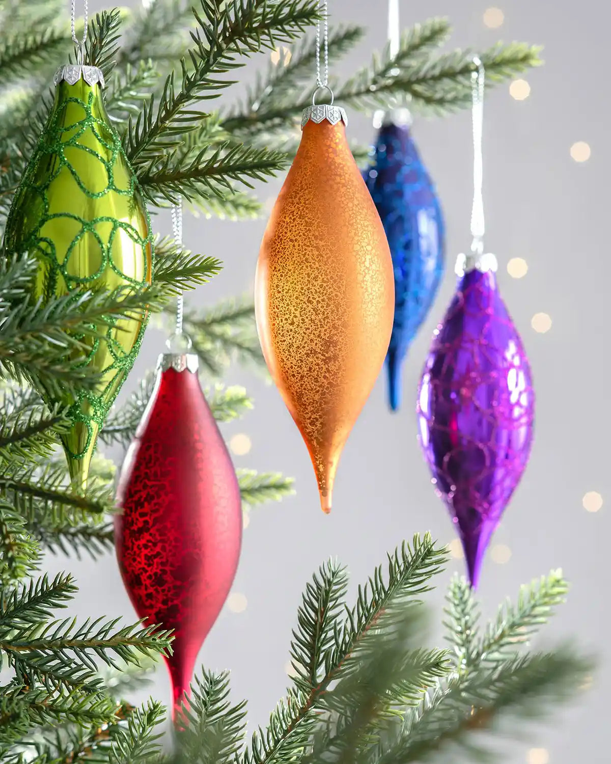 Multicolour glass finial baubles displayed on decorated Christmas tree