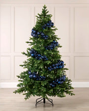 Navy bauble cluster arch styled around a green Christmas tree with shiny, matt and glitter baubles.