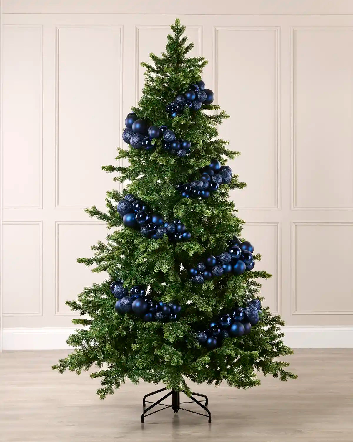 Navy bauble cluster arch styled around a green Christmas tree with shiny, matt and glitter baubles.