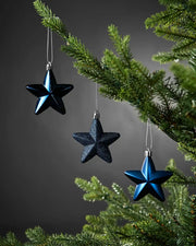 Navy blue 7cm hanging star decorations in shiny, glitter and matte finishes displayed on a Christmas tree.