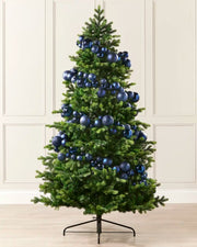 Navy blue bauble garland wrapped around a green Christmas tree with mixed shiny, matt and glitter baubles.
