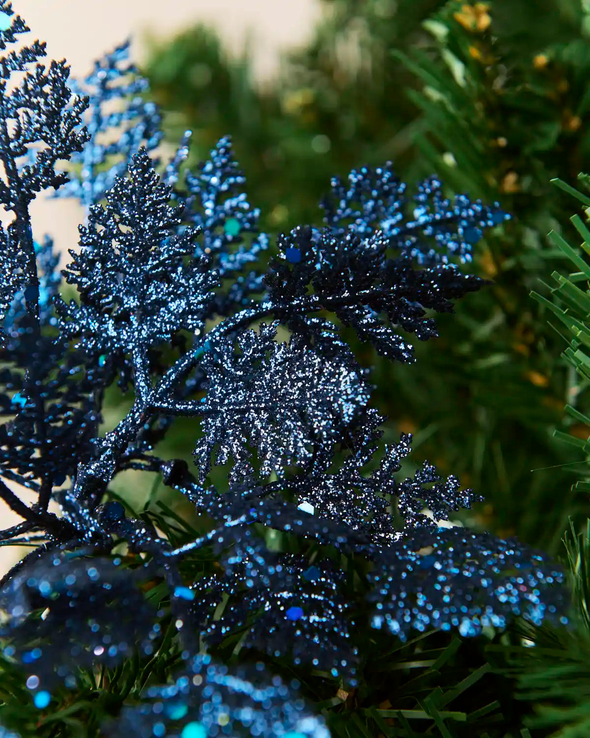 Detailed view of layered navy glitter leaves with sparkling surfaces and blue sequin accents.