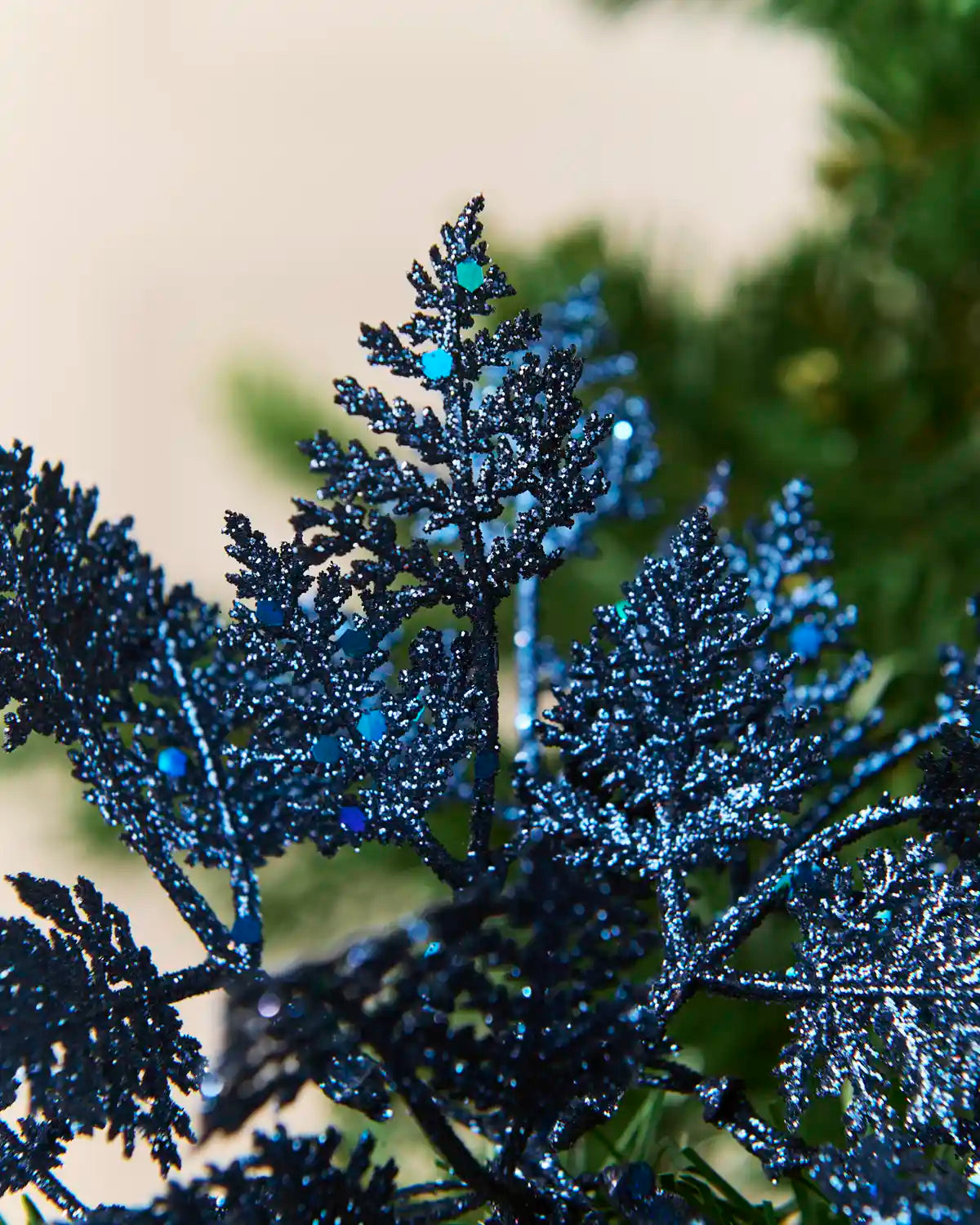Close-up of navy glitter leaves with reflective blue sequins and detailed branching edges.