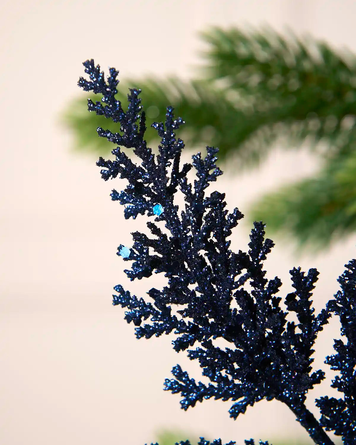 Close-up of navy glitter leaf foliage with reflective sequin detailing and sparkling finish.
