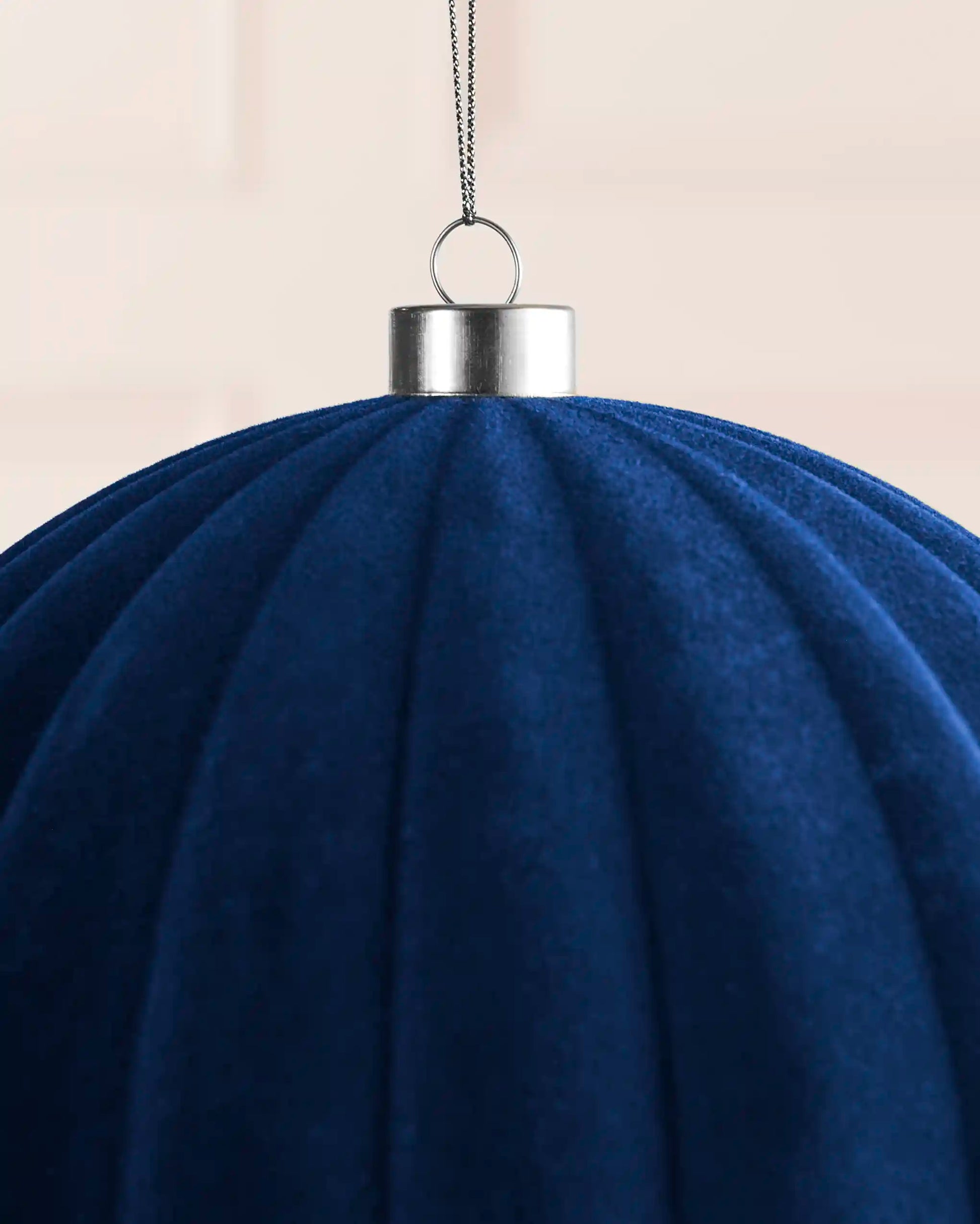 Close-up of a navy 20 cm oversized velvet bauble showing its ribbed texture and silver cap.