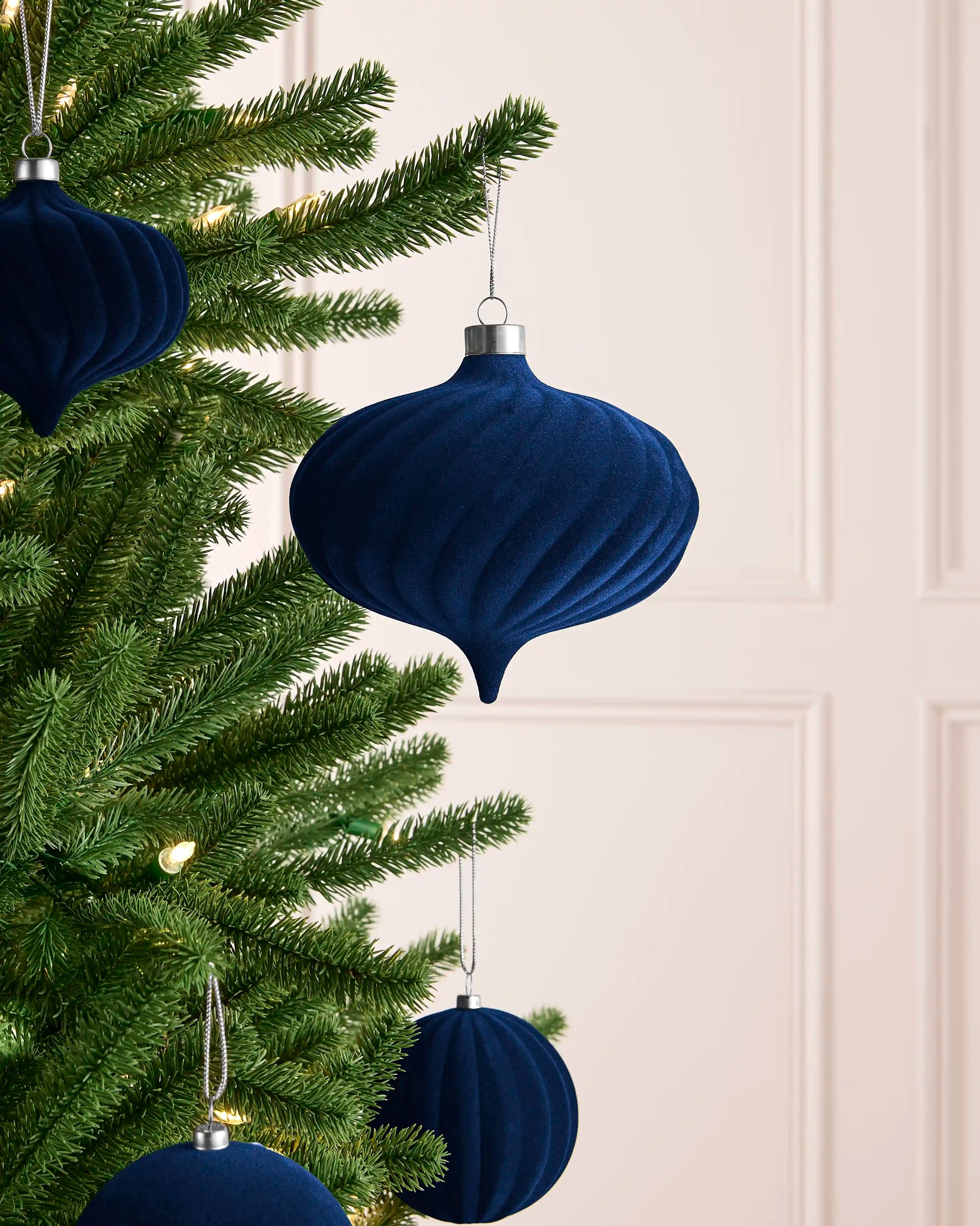 Navy 15 cm oversized spiral velvet bauble displayed among coordinating navy decorations on a Christmas tree.