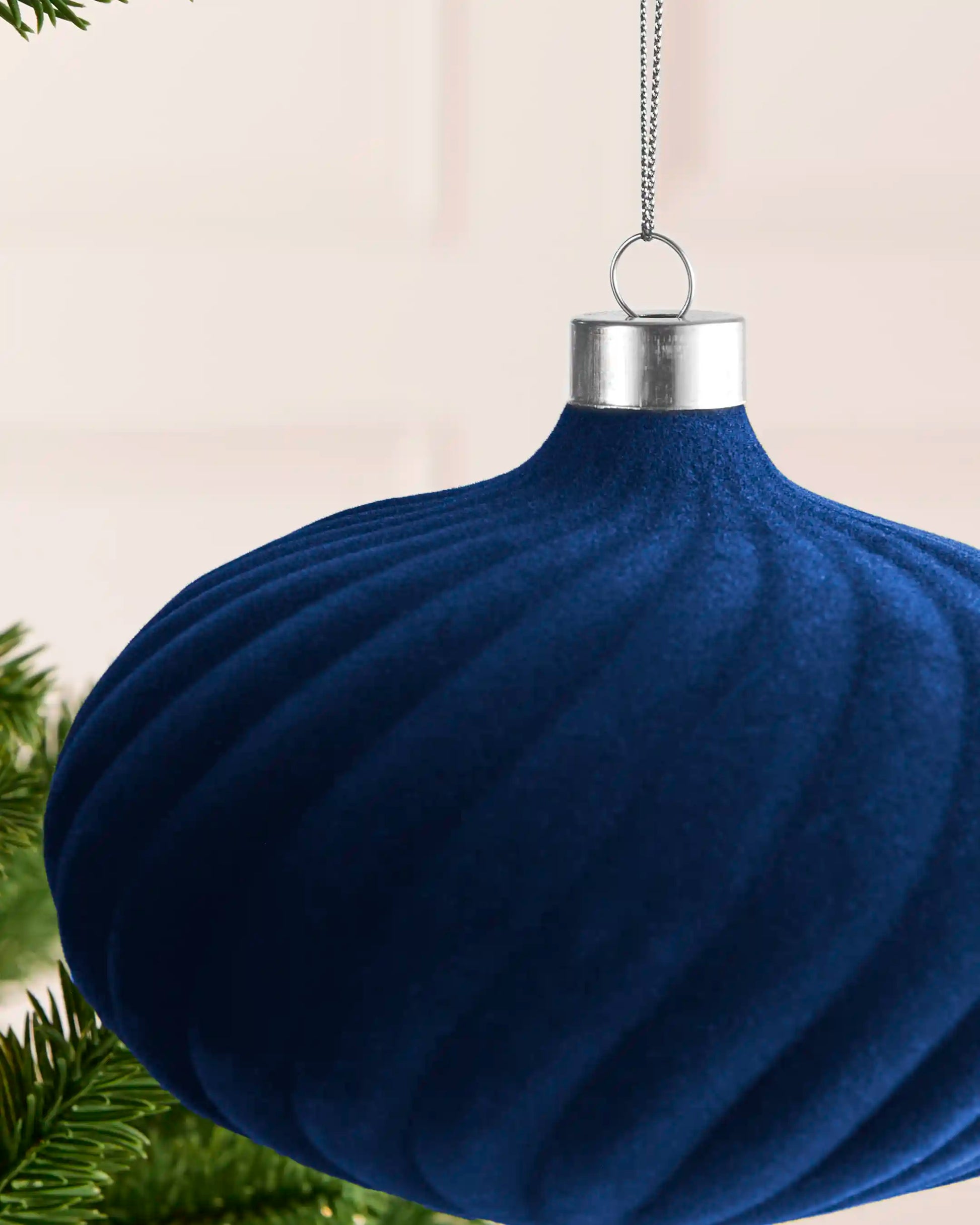 Close-up of the navy velvet spiral detailing, silver metal cap and hanging string on the 15 cm bauble.