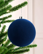 15 cm navy oversized velvet traditional bauble hanging on a Christmas tree with a silver cap and silver hanging string.