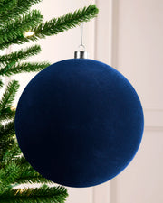 20 cm navy oversized velvet traditional bauble hanging on a Christmas tree with a silver cap and hanging string.