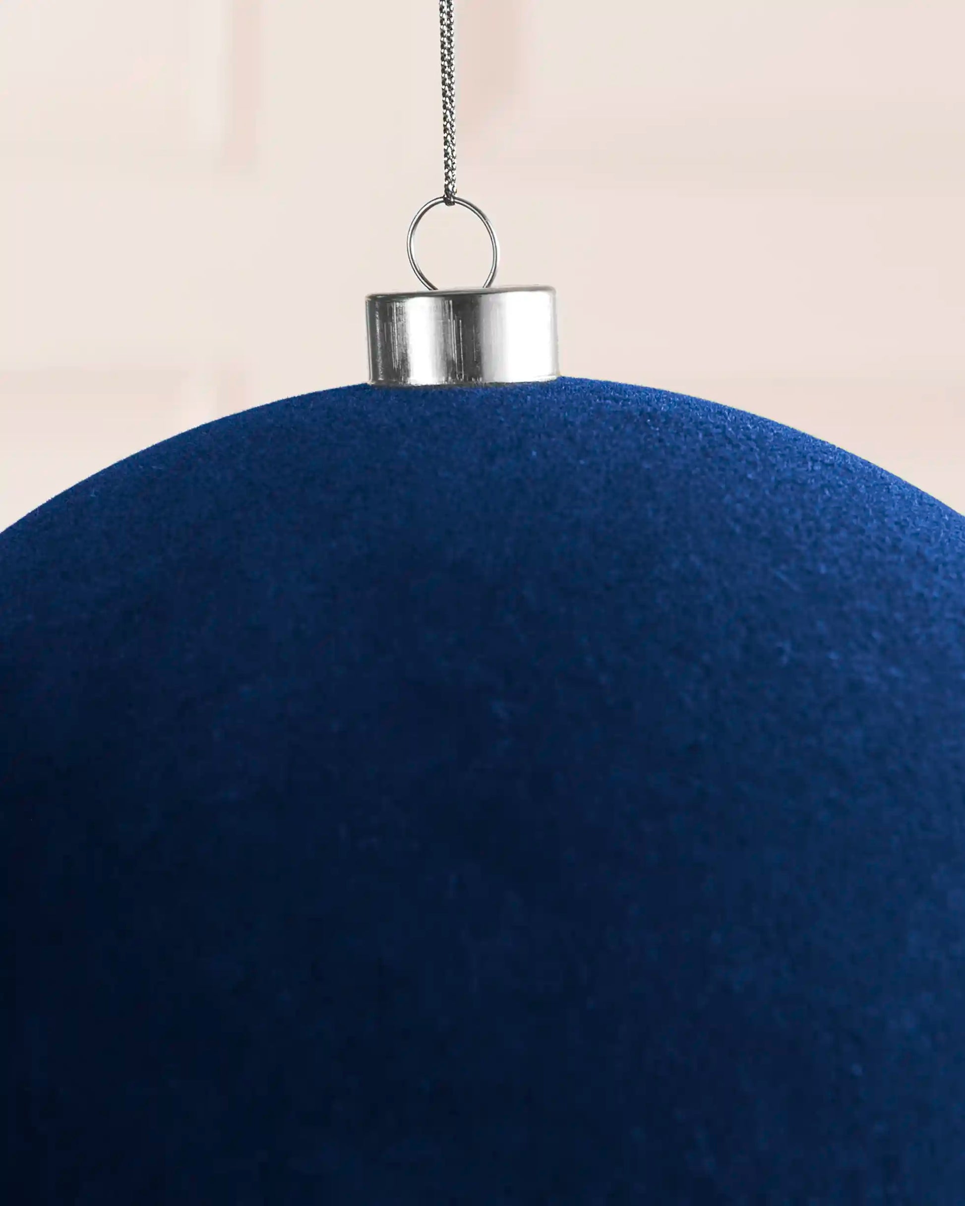 Close-up of a navy 20 cm oversized velvet traditional bauble showing the velvet finish and silver cap.