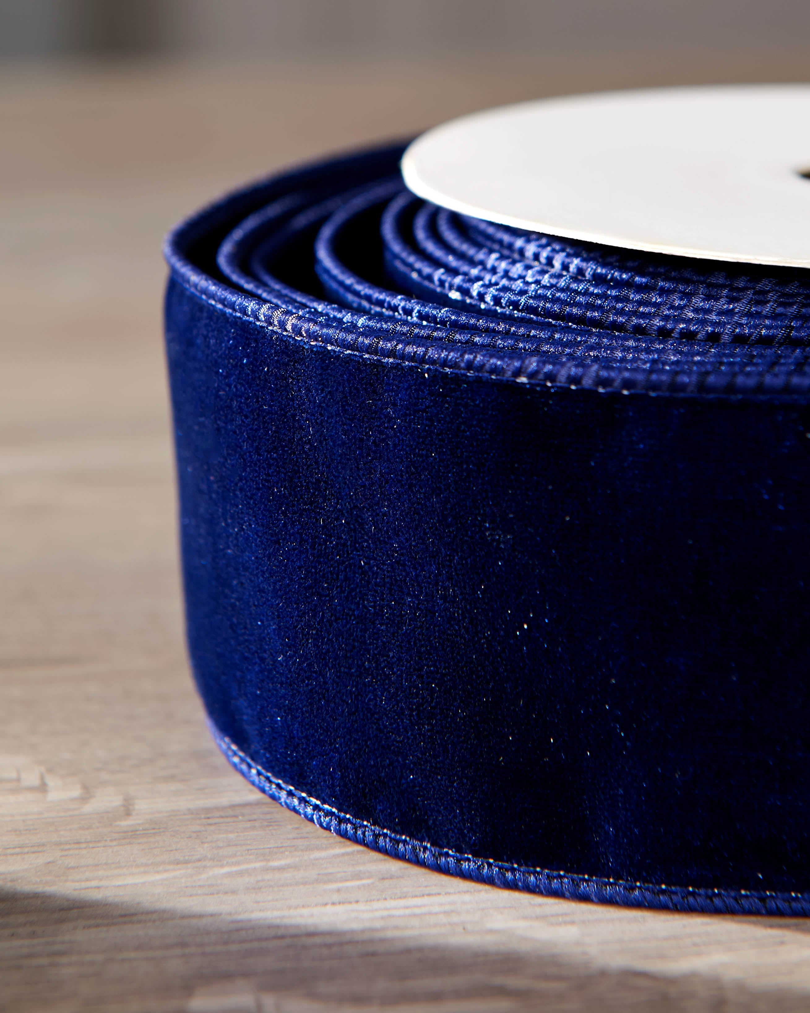 Close-up of navy velvet ribbon on a roll, showing the soft texture and wired edge.