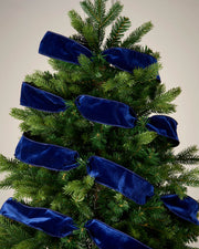 Navy velvet ribbon wrapped around a Christmas tree as a festive decoration.