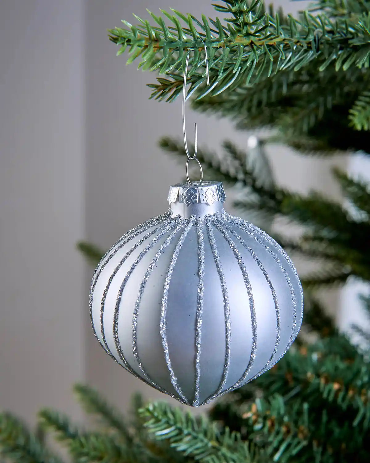 Silver bauble ornament hook securing a Silver Christmas bauble to a tree branch