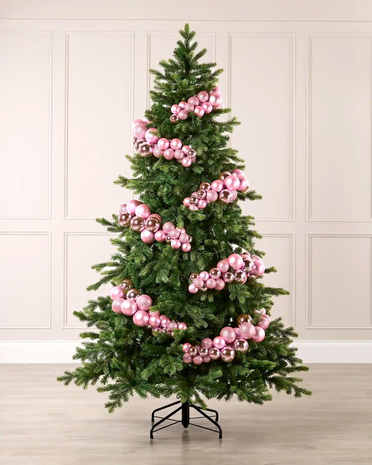 Pink bauble cluster arch styled around a green Christmas tree with shiny, matt and glitter baubles.