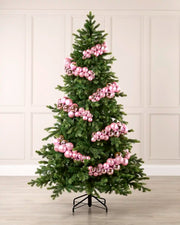 Pink bauble cluster arch styled around a green Christmas tree with shiny, matt and glitter baubles.
