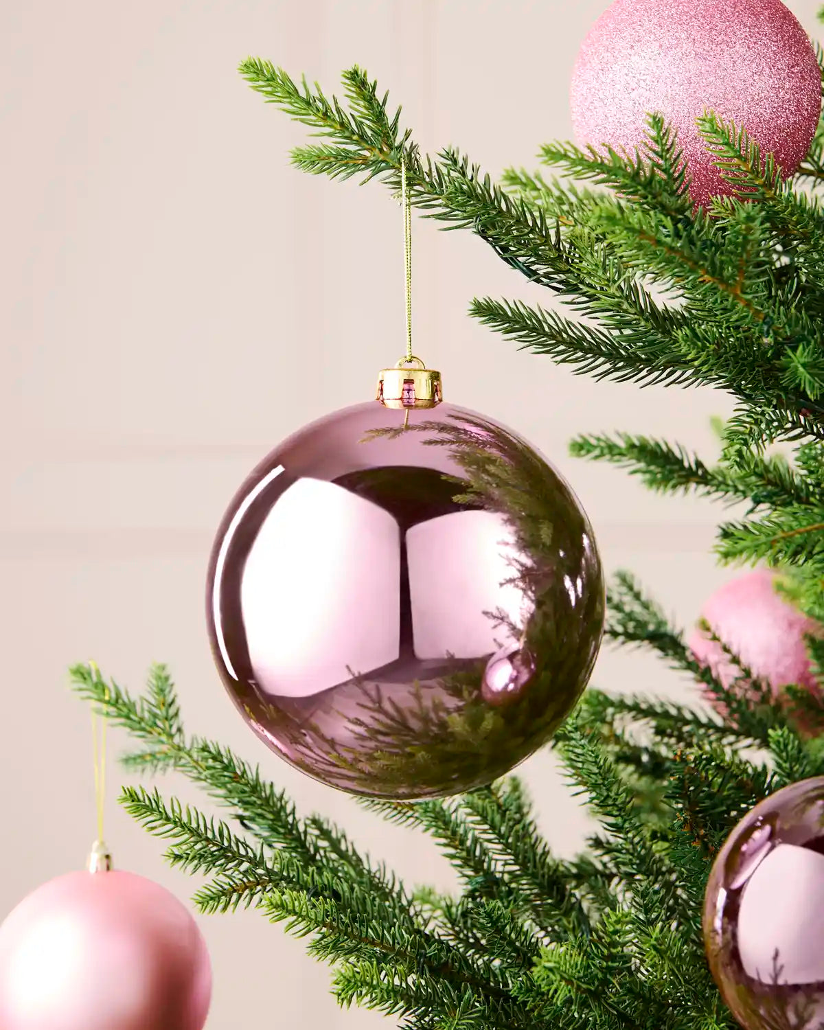 Pink 15 cm shiny shatterproof bauble displayed on a Christmas tree with coordinating pink baubles.