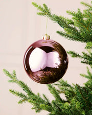 Shiny pink oversized shatterproof bauble measuring 15 cm, hanging from an artificial Christmas tree with a gold cap and string.