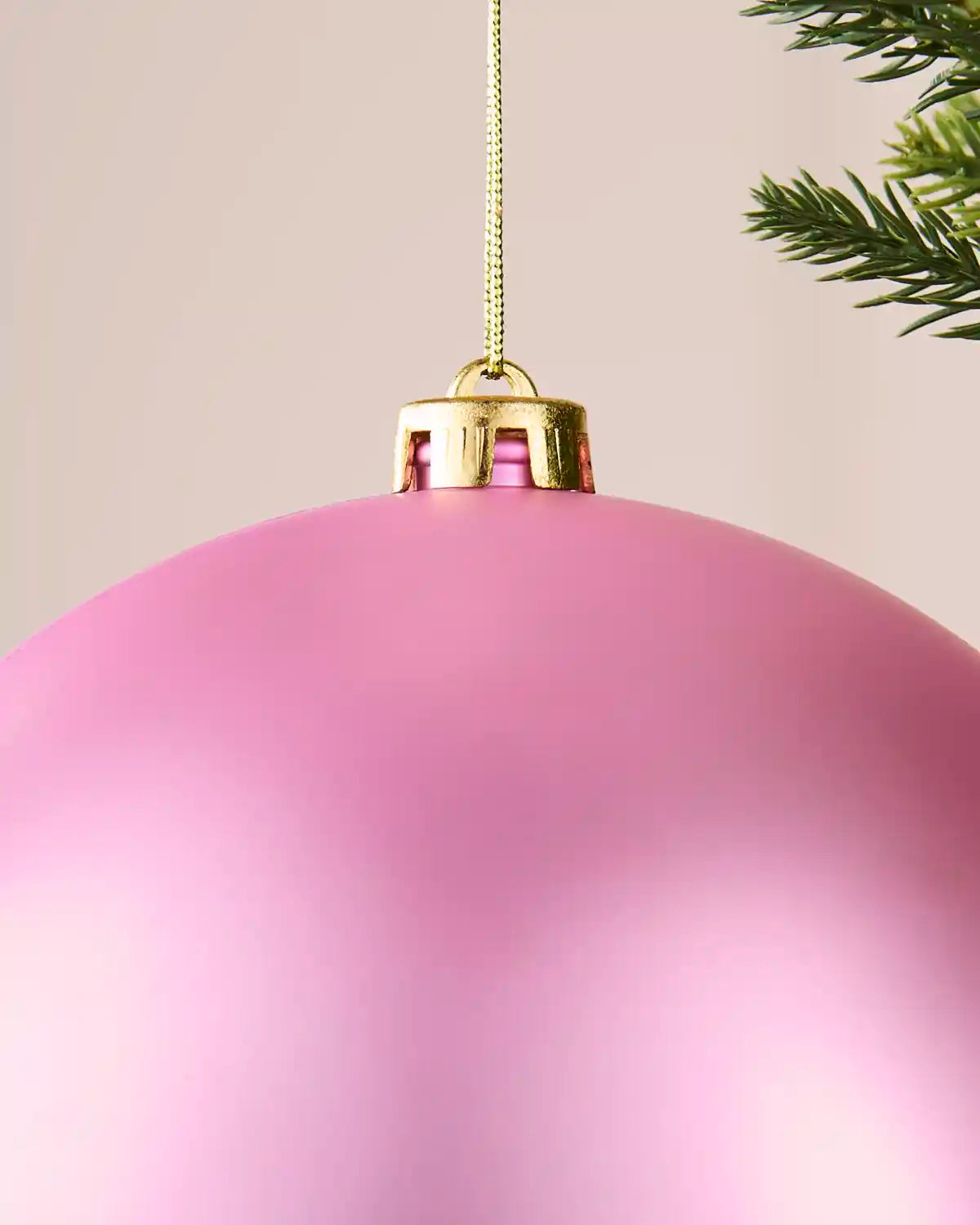 Detailed close-up of the 20 cm matt pink shatterproof bauble with its gold cap and matching hanging string.