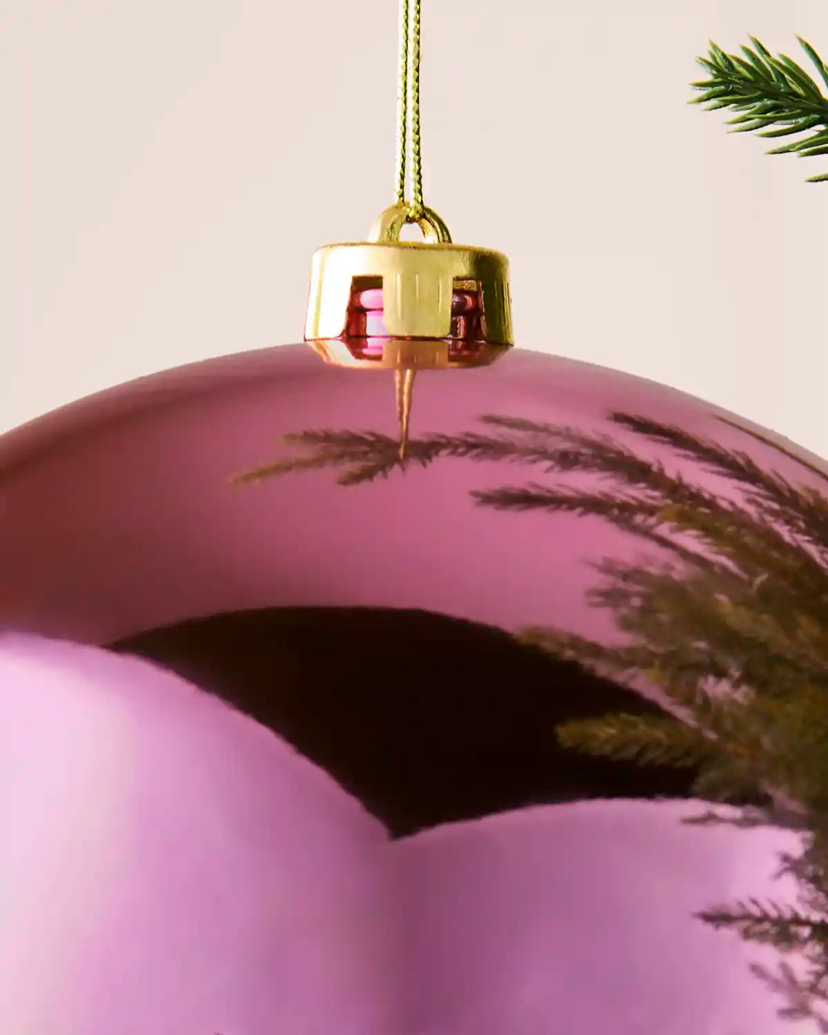 Detailed close-up of the 20 cm shiny pink shatterproof bauble with its gold cap and matching hanging string.