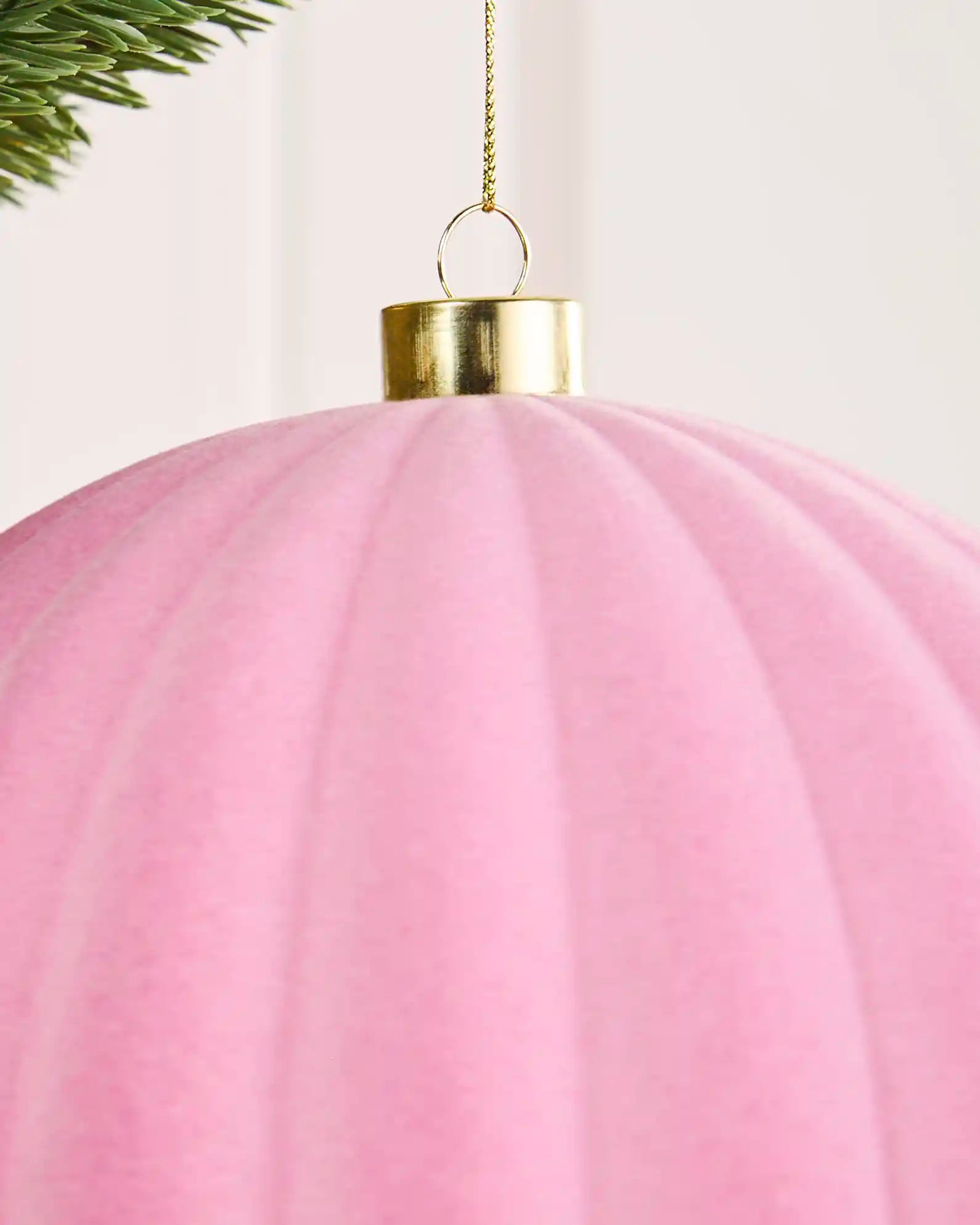 Close-up of a pink 20 cm oversized velvet ribbed bauble showing the soft texture, ribbed surface and gold cap.
