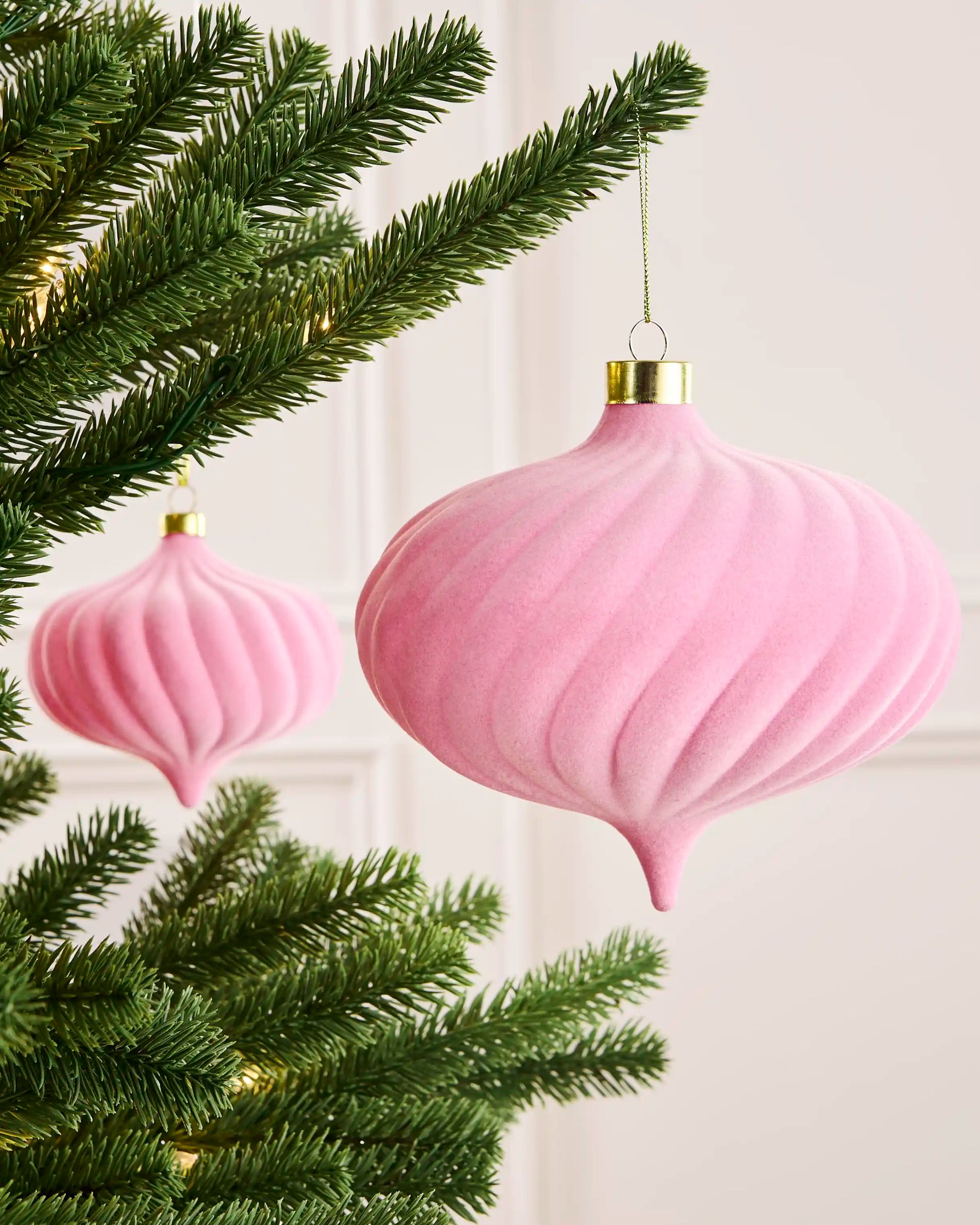 Pink 15 cm oversized velvet spiral bauble displayed on a Christmas tree with a coordinating pink ornament behind.