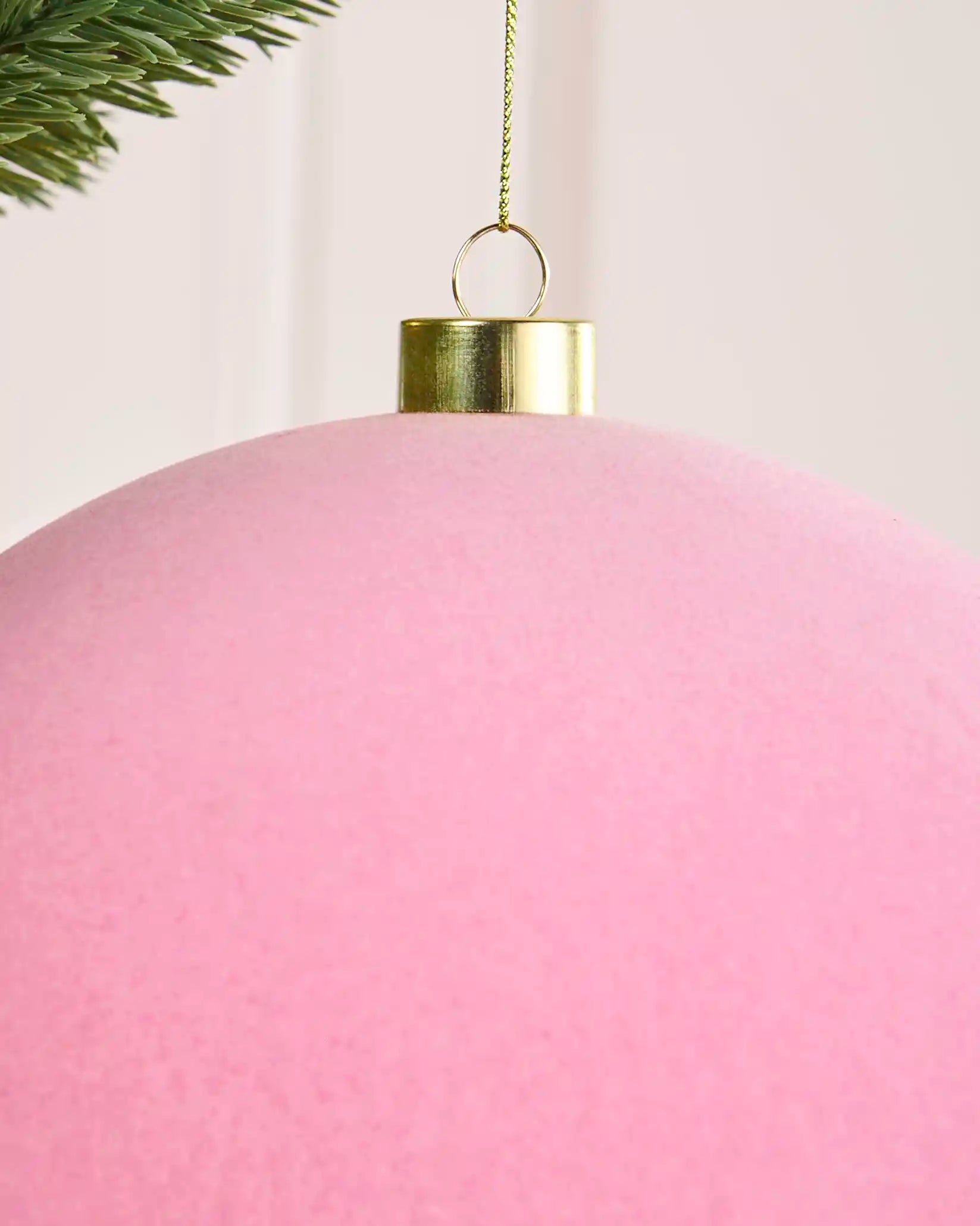 Close-up of a pink 20 cm oversized velvet traditional bauble showing the soft finish and gold cap.