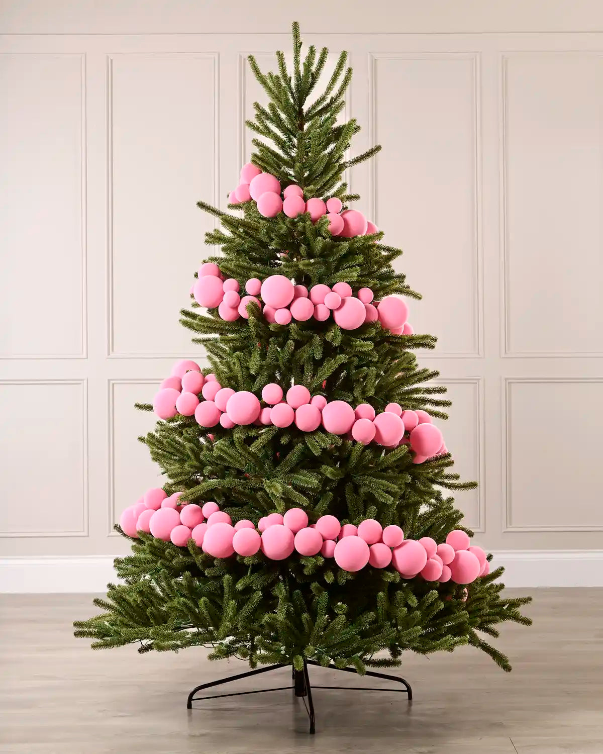 Pink velvet bauble garland wrapped around a green Christmas tree with mixed 5cm, 7cm and 10cm baubles.