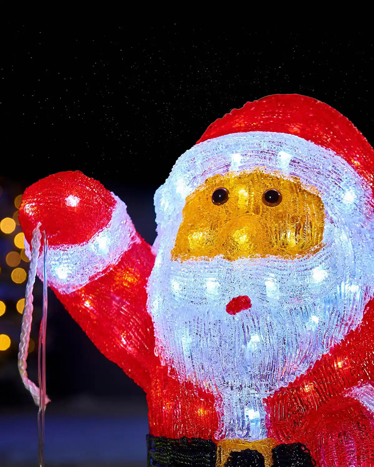 Close-up of illuminated acrylic Santa figurine face with red hat and white beard
