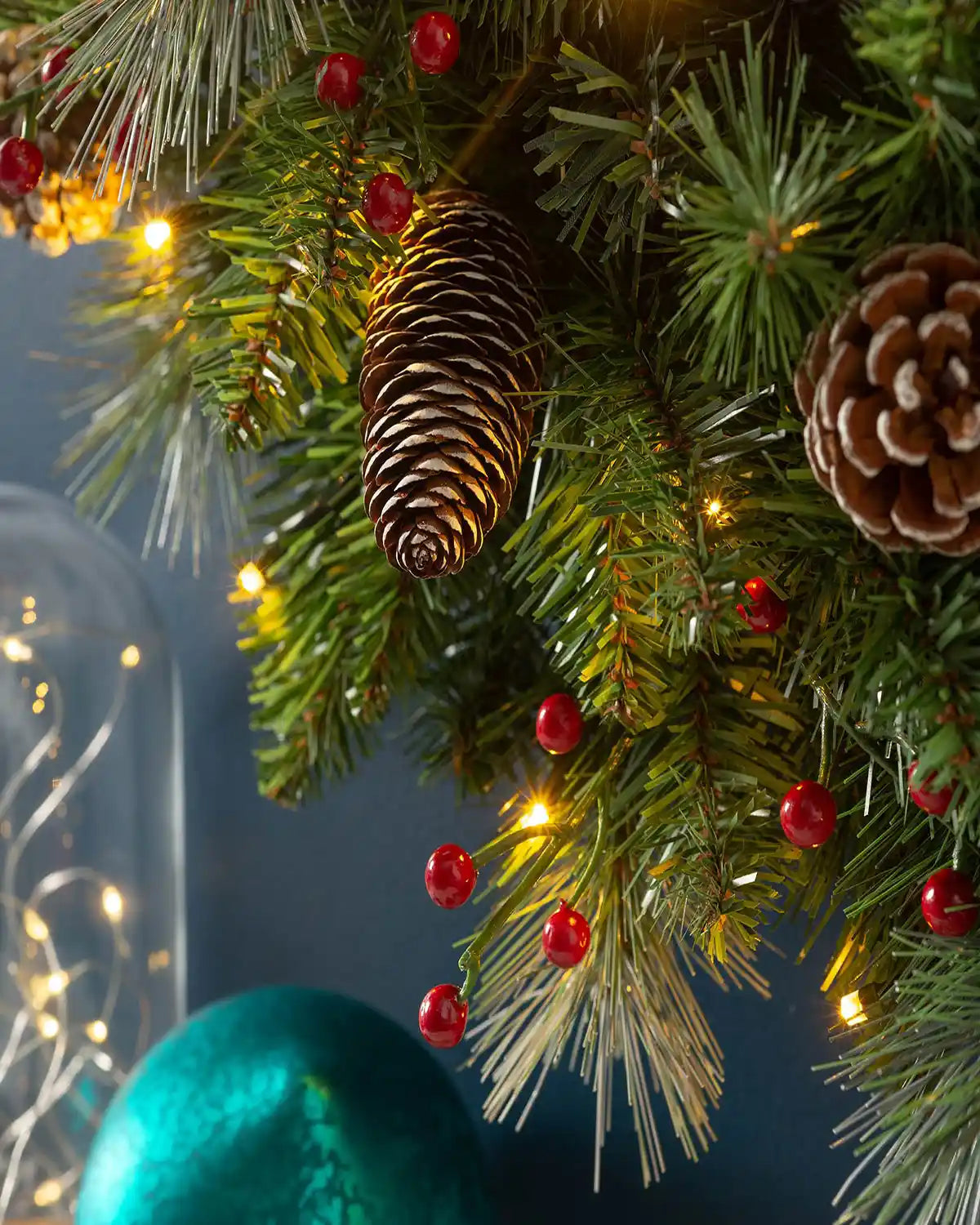 Close-up of 60 cm pre-lit frosted Christmas wreath with pinecones, red berries and warm white lights