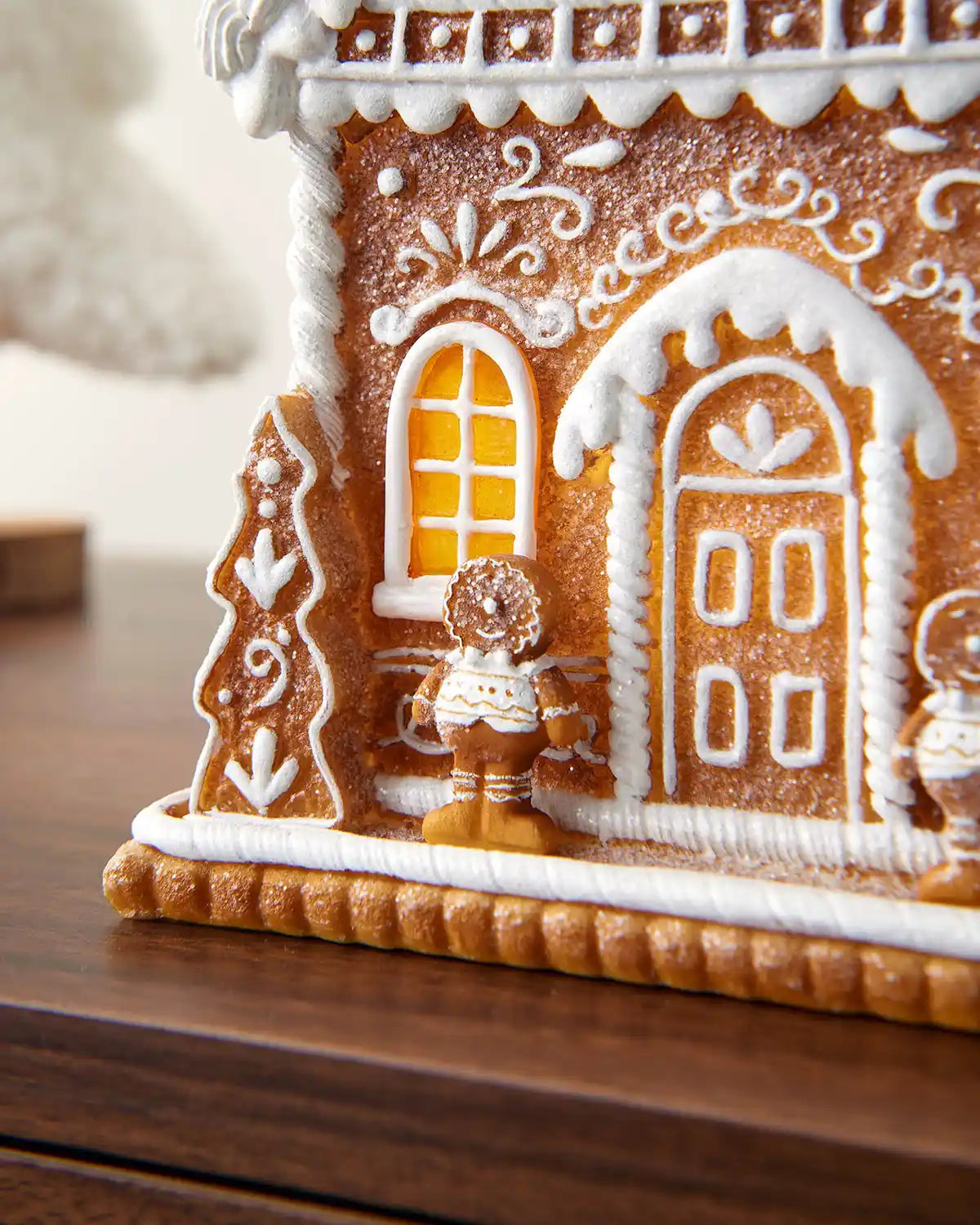 Close-up of the 22cm gingerbread house showing a gingerbread figure, window, door and piped icing-style details.