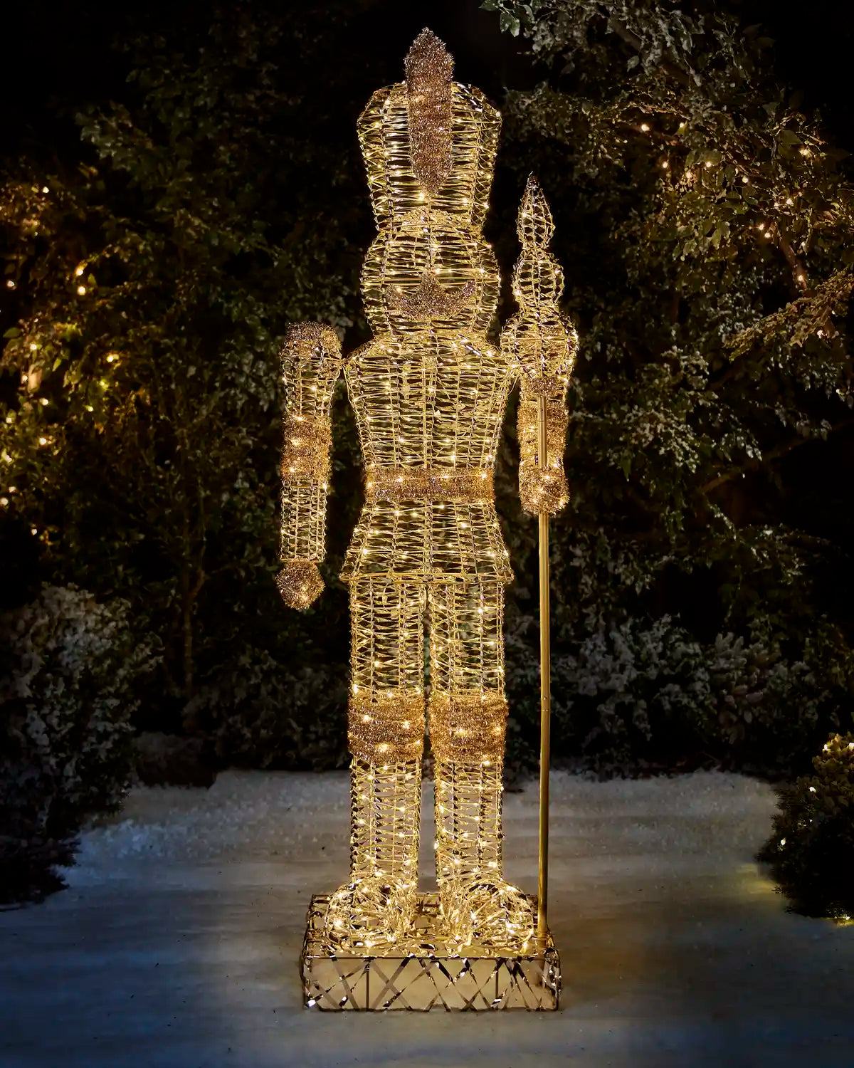 Full-length 6.5 ft pre-lit gold nutcracker with warm white LED lights in an outdoor Christmas display.
