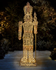 Full-length 6.5 ft pre-lit gold nutcracker with warm white LED lights in an outdoor Christmas display.