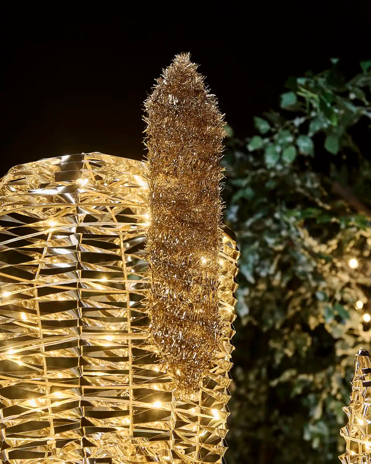 Close-up of the pre-lit gold nutcracker’s feather-topped hat with gold tinsel detailing.